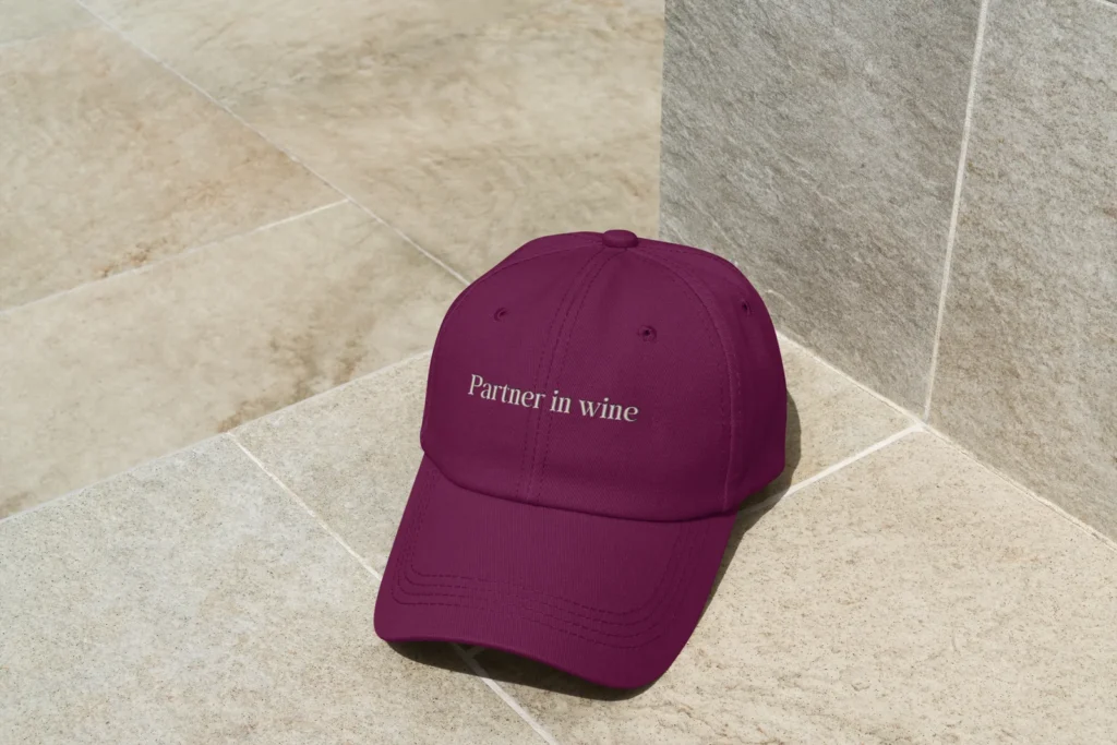 Gorra tyrian purple More Wine Please sobre piso de baldosa